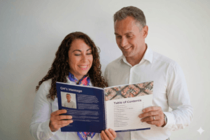 Gemini_Generated_Image_47nkr147nkr147nk Two coworkers in white shirts smiling as they read a blue brochure with a table of contents.